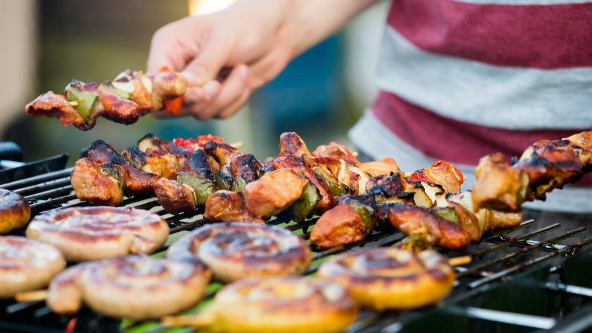 midsection of man barbecuing at garden party